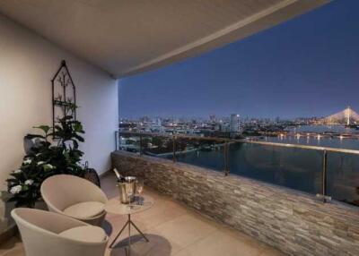 Spacious balcony with comfortable seating overlooking the city skyline at night