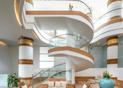 Elegant multi-level atrium with spiral staircase and modern furnishings