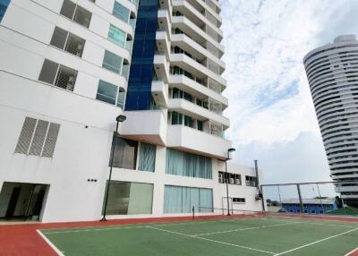 Modern high-rise residential building with outdoor tennis court
