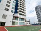 Modern high-rise residential building with outdoor tennis court