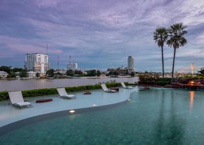 Tranquil outdoor swimming pool with skyline view at dusk