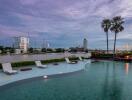 Tranquil outdoor swimming pool with skyline view at dusk