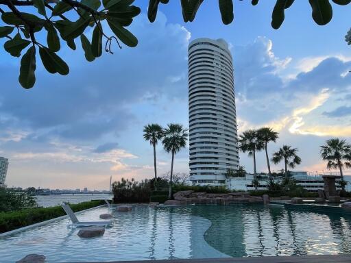 Modern high-rise residential building seen from pool area at dusk