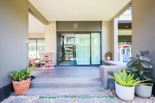 Spacious and well-lit entrance with patio leading to modern glass doors