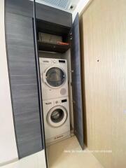 Compact in-home laundry area with modern washing machine