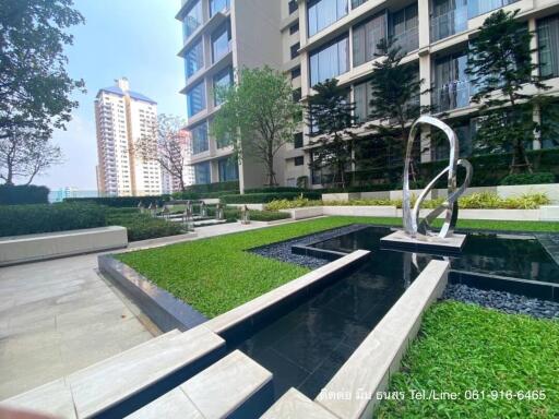 Modern apartment complex outdoor common area with landscaping and art sculpture