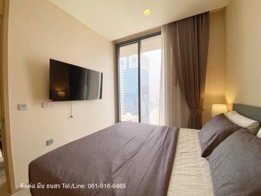 Modern bedroom with a large bed and a mounted TV