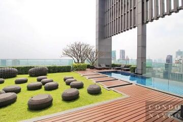 Modern rooftop garden with city view, wooden decking, and outdoor furniture