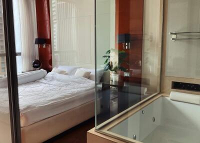Modern bedroom with adjacent glass-enclosed bathtub