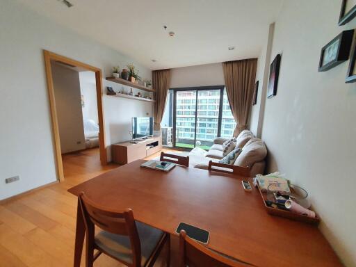 Cozy and well-lit living room with a comfortable seating area and balcony access