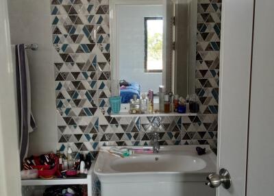 Modern bathroom with patterned wall tiles and white fixtures