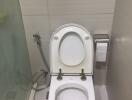 Clean white bathroom toilet with wall tiles