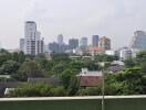 Panoramic view of a city with various buildings and lush greenery