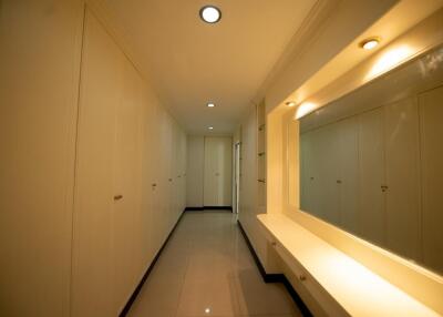 Brightly lit hallway with built-in storage cabinets and seating area