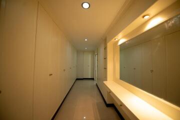 Brightly lit hallway with built-in storage cabinets and seating area