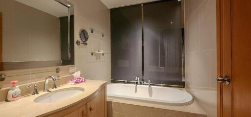 Modern bathroom with a bathtub and shower combo, well-lit vanity area, and wall-mounted mirror
