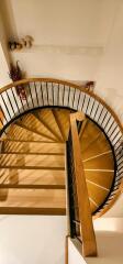 Elegant wooden spiral staircase with wrought iron railing