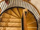 Elegant wooden spiral staircase with wrought iron railing