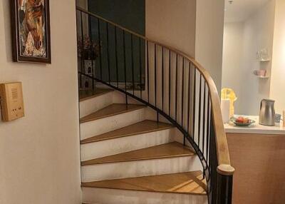 Elegant staircase with wood finish and black wrought iron banister in a home interior