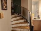 Elegant staircase with wood finish and black wrought iron banister in a home interior