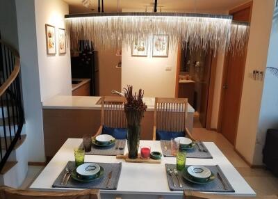 Modern dining area with open concept kitchen and stylish chandelier