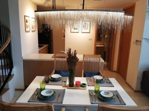Modern dining area with open concept kitchen and stylish chandelier