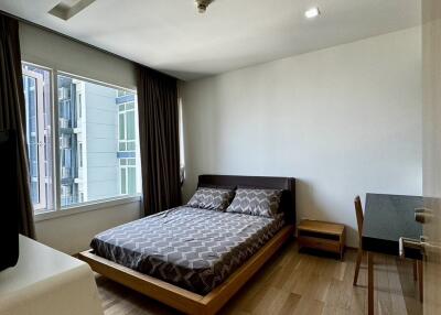 Modern bedroom with natural light and wooden flooring