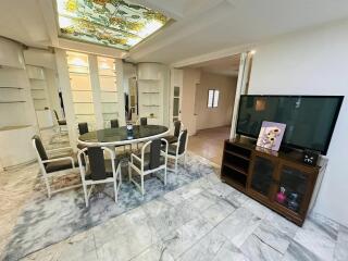 Spacious living room with open dining area, marble flooring, and decorative ceiling