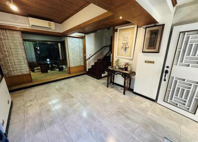 Spacious living room with tiled flooring, staircase, and ample natural light