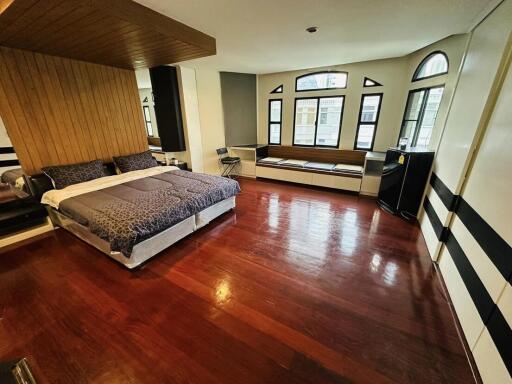 Spacious bedroom with hardwood floors and large windows