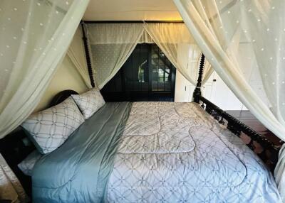 Cozy bedroom with a four-poster bed and sheer curtains