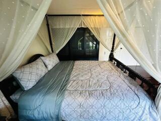 Cozy bedroom with a four-poster bed and sheer curtains