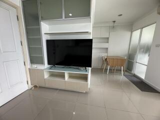Spacious living room with modern entertainment unit and ample natural light