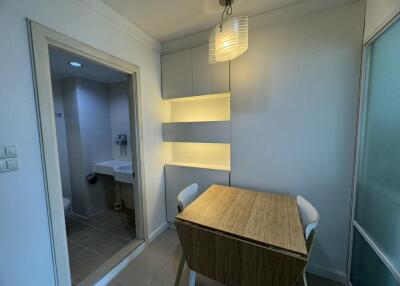 Compact dining area with wooden table and chairs adjoining a bathroom