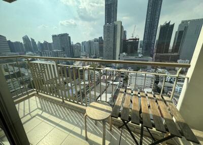 Spacious balcony with city skyline view featuring wooden furniture