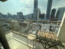 Spacious balcony with city skyline view featuring wooden furniture