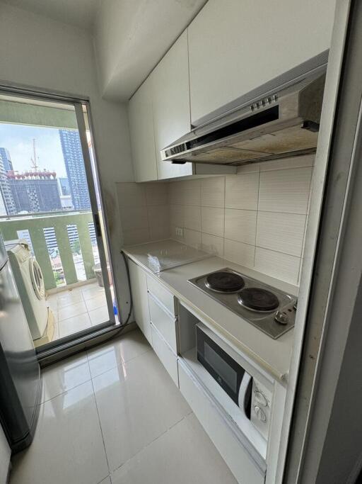 Compact kitchen space with modern appliances and city view