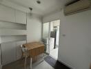 Compact kitchen with wooden table, built-in shelves, and modern appliances