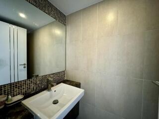 Modern bathroom interior with white sink and mosaic tile accents
