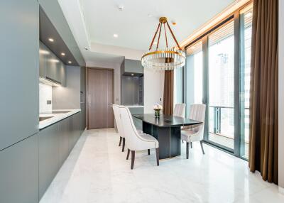 Modern kitchen with dining area, full-length windows, and chandelier