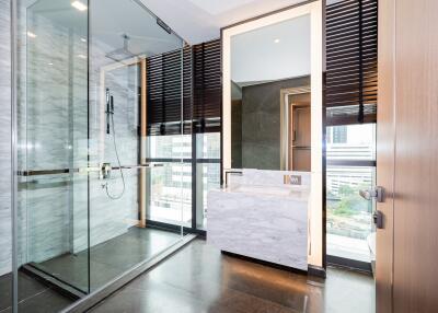 Modern bathroom interior with glass shower cabin and marble tiles