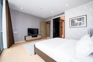 Modern bedroom with large bed, flat-screen TV, and elegant decor