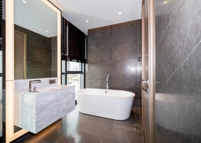 Modern bathroom with freestanding tub, large mirror, and glass shower