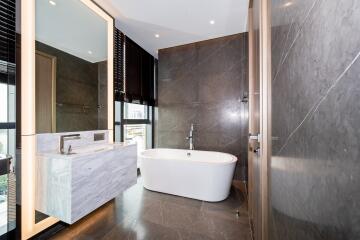 Modern bathroom with freestanding tub, large mirror, and glass shower