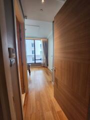 Bright apartment corridor leading to a living room with natural light