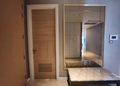 Modern entrance hallway with wooden door and built-in mirrored wardrobe