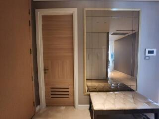 Modern entrance hallway with wooden door and built-in mirrored wardrobe