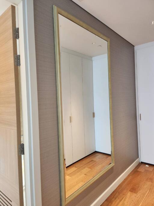 Modern corridor with wooden flooring and a large mirror