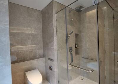 Modern bathroom with glass shower enclosure and marble tiles