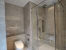 Modern bathroom with glass shower enclosure and marble tiles